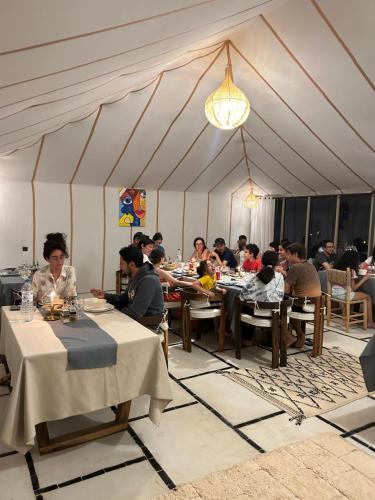 a group of people sitting at tables in a tent at Camp Sakura Desert Dream in Merzouga