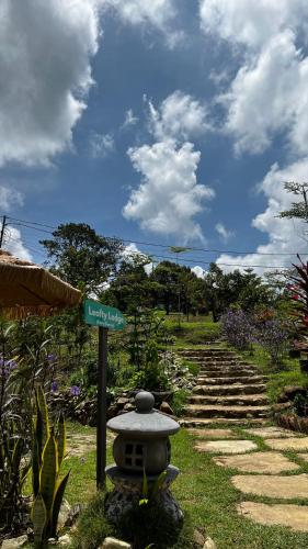 a street sign in a garden with a pathway at 4 Simple Minimalistic Rooms at Sunset Lodge - Eco Valley Retreat 豐之谷 in Balung