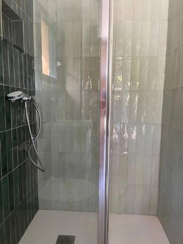 une douche avec une porte vitrée dans une salle de bain dans l'établissement The Cube, à Peille