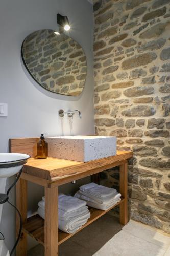 a bathroom with a sink and a stone wall at Panfilo Farmhouse in Cellino Attanasio