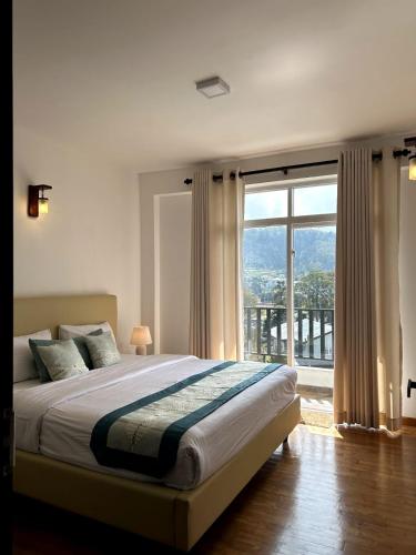 a bedroom with a large bed with a large window at Nomentano Blue -Luxury Apartments- in Nuwara Eliya