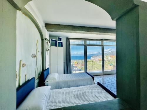 a room with two beds and a large window at Casa Mazzola in Sant'Agnello