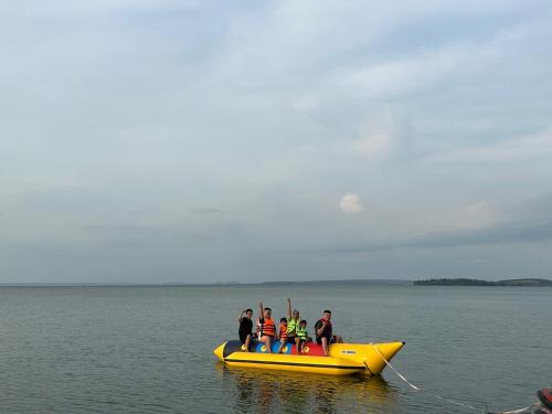 un grupo de personas en una balsa amarilla en el agua en Trị An Villa en Xã Trảng Bôm