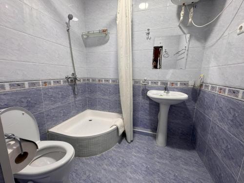 uma casa de banho com um WC, um lavatório e um WC. em M Hotel Khiva em Khiva