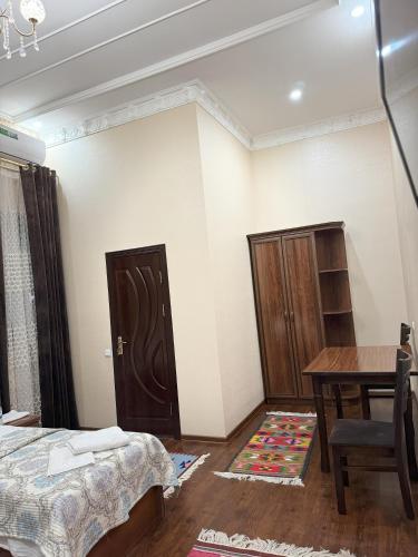 Zimmer mit einem Tisch und einem Bett sowie einem Tisch und Stühlen in der Unterkunft M Hotel Khiva in Xiva