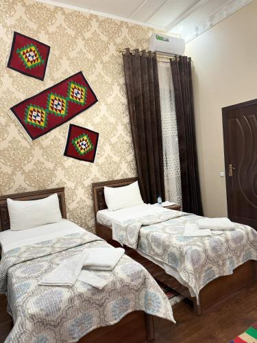 um quarto com duas camas e uma parede em M Hotel Khiva em Khiva