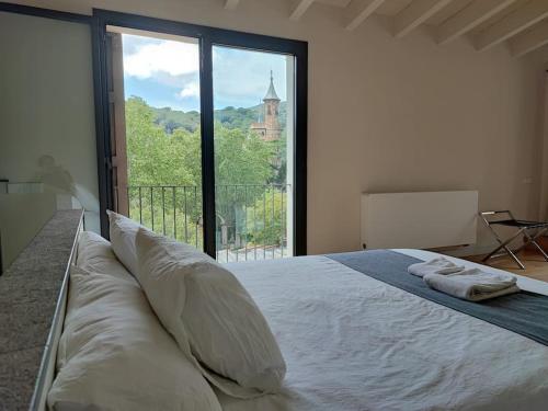 - une chambre avec un grand lit et une grande fenêtre dans l'établissement Designer home with pool near beach and village, à Alella