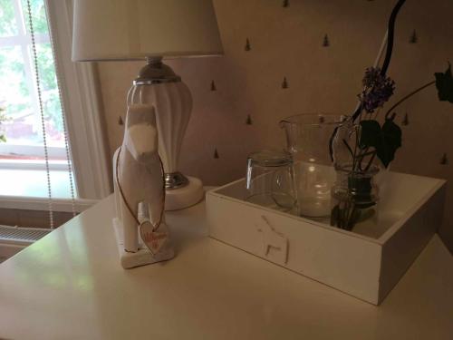 einen Nachttisch mit einer Lampe und einer Schachtel darauf in der Unterkunft Kopparstugans Bed & Breakfast in Falun