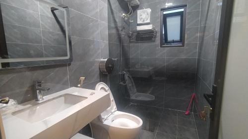 een badkamer met een wastafel, een toilet en een douche bij Nhà nghỉ Thiện Trang in Kiến An