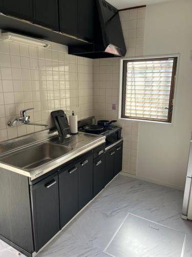 a kitchen with a stainless steel sink and a window at 3minutes from the station Close to Asakusa, Tokyo Station and Narita Airport in Tokyo