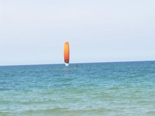 a person riding a kite in the ocean at Reda in Mielno