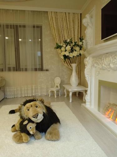 um leão empalhado sentado no chão de uma sala de estar em 3-комн. апартаменты в районе Болашак em Qyzylorda