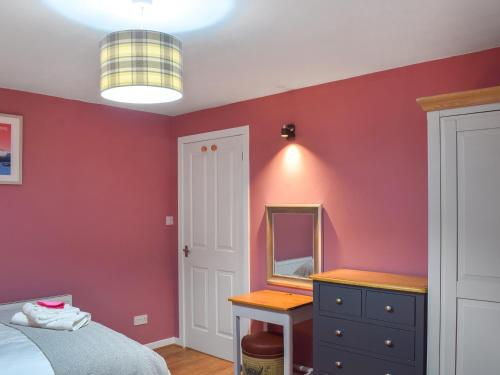 a bedroom with red walls and a mirror and a bed at Riverview in Bridge of Allan