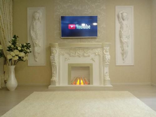 a living room with a fireplace with a tv above it at 3-комн. апартаменты в районе Болашак in Qyzylorda