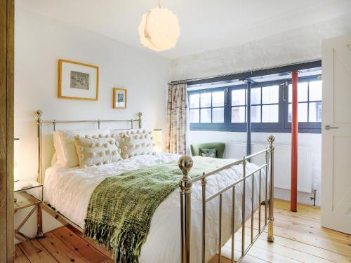 a bedroom with a bed and a window at The Old Stables in Totnes