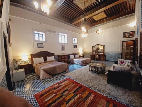 een slaapkamer met 2 bedden en een woonkamer bij Palais Al Firdaous in Fès