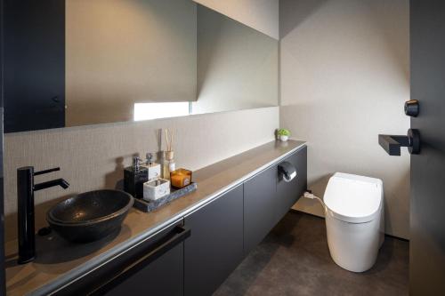 a bathroom with a sink and a toilet at Meikeikyo Hanazono in Kutchan