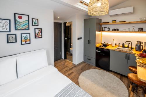 a bedroom with a white bed and a kitchen at Primera Suite in Istanbul