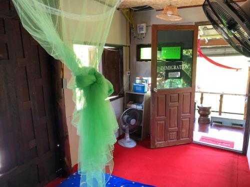 einen grünen Schleier auf einem Zimmer mit Tür in der Unterkunft Baan Sudjai homestay 