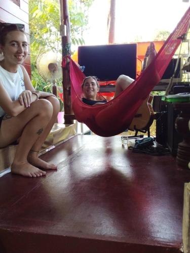 two girls sitting in a hammock in a room at Baan Sudjai homestay 