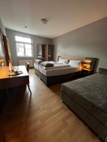 的住宿－Hotel und Restaurant Adler，一间卧室配有两张床、一张桌子和一张书桌