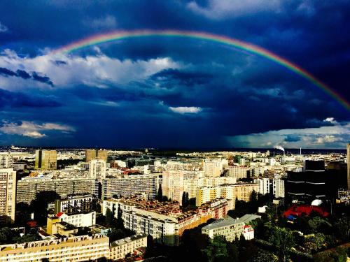 a rainbow in the sky over a city at Appartement très haut avec Piscine, sauna, salle de sport et solarium in Paris