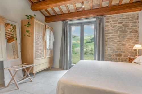 Cellino Attanasio的住宿－B&B Panfilo Farmhouse，一间卧室设有一张大床和一个窗户。