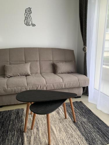 uma sala de estar com um sofá e uma mesa de centro em La colline aux oiseaux em Caen