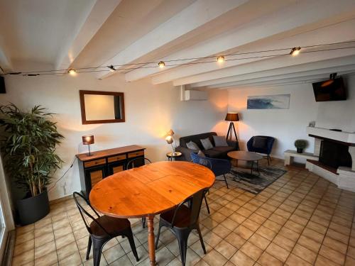 un salon avec une table et des chaises en bois dans l'établissement Maisonnette 3 chambres - Confort, à Biscarrosse