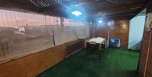 ein leeres Zimmer mit einem Schreibtisch und grünem Boden in der Unterkunft alojamiento particular playa chanavayita in Iquique