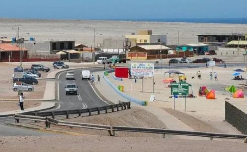 a road with cars parked in a parking lot at alojamiento particular playa chanavayita in Iquique