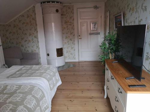a bedroom with a bed and a flat screen tv at Kopparstugans Bed & Breakfast in Falun
