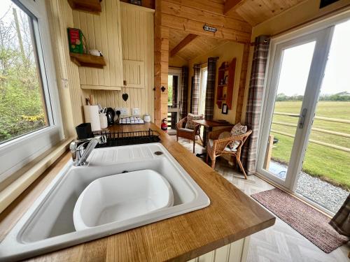 a kitchen with a large sink in a tiny house at Shepherds Retreat Anglesey in Llanerchymedd