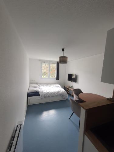 Habitación blanca con cama, escritorio y escritorio. en Studio au calme dans résidence Gauguin pour location courte durée et étudiants en Gières
