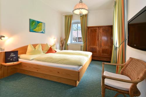 ArriachにあるPension Pilsachhofのベッドルーム(大型ベッド1台、椅子付)