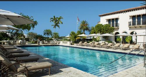 a swimming pool with chairs and umbrellas next to a building at SoCal Lux on Bixel in Los Angeles