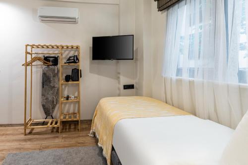 a hotel room with a bed and a tv at Mariposa Rooms Taksim in Istanbul