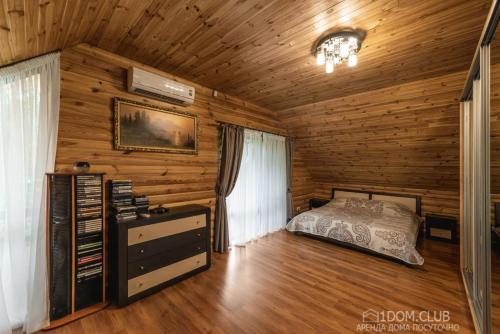 ein Schlafzimmer mit einem Bett in einer Holzhütte in der Unterkunft Дом на берегу in Protsev