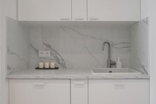 - une cuisine blanche avec un évier et des placards blancs dans l'établissement Spacieux Summer Getaway Ideal Apartment for 6, à Nice