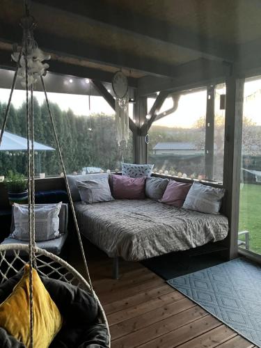 a swinging bed in a porch with a large window at Glamping Karavan in Chrášťany