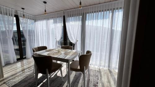 a dining room with a white table and chairs at Садиба Кичера та Кичера Еко in Mizhhirʼʼya