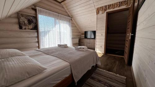 a bedroom with a bed with two towels on it at Садиба Кичера та Кичера Еко in Mizhhirʼʼya