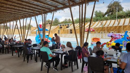 un grupo de personas sentadas en mesas en un parque acuático en Hotel Gran Marquez en Moquegua
