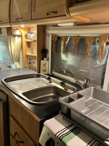 a kitchen in an rv with a sink and aaptop at Glamping Karavan in Chrášťany