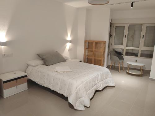 a bedroom with a bed and a table and a chair at Increible Loft en el Corazon de Lorca in Lorca