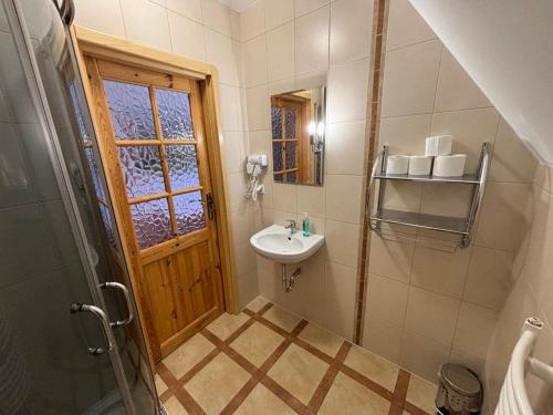a small bathroom with a sink and a mirror at Villa Szarotka in Dzianisz