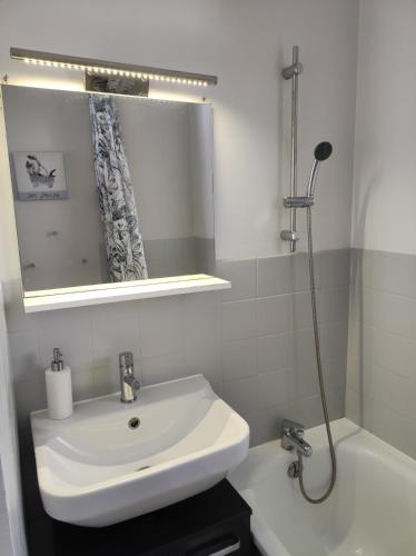 une salle de bain avec un lavabo, un miroir et une baignoire dans l'établissement F2 50m de la mer avec parking privé, à Valras-Plage