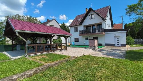 a large white house with a gazebo at Artemis Vendégház in Bogács