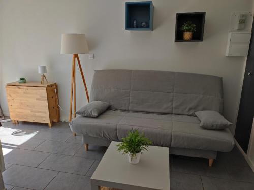 a living room with a couch and a table at F2 50m de la mer avec parking privé in Valras-Plage