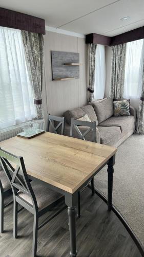 a living room with a table and a couch at B1 - Pebble Bank Caravan Park in Weymouth